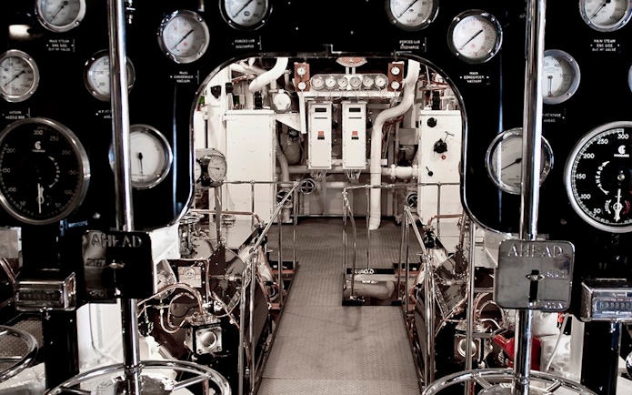 Engine room with control panels and gauges on a ship.