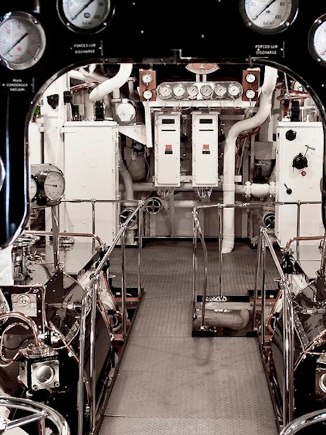 Engine room with control panels and gauges on a ship.
