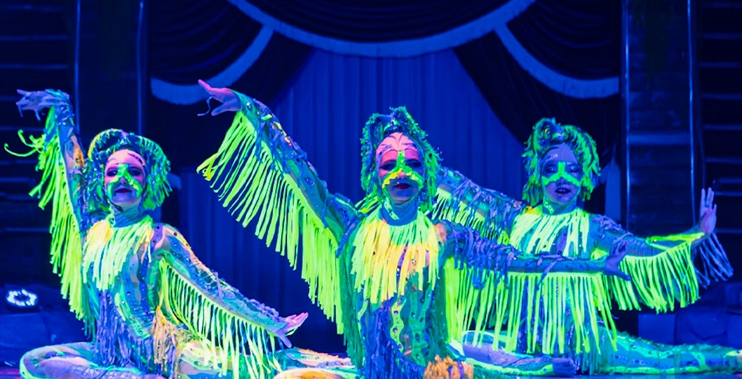 Performers in neon costumes at Aqua Circus show.