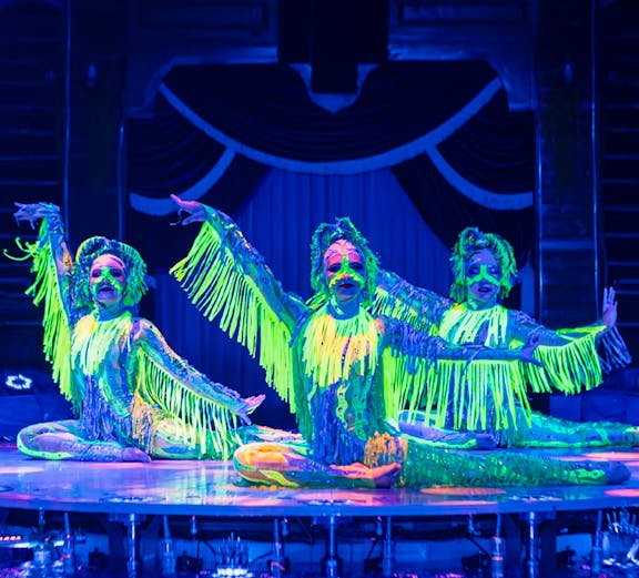 Performers in neon costumes at Aqua Circus show.