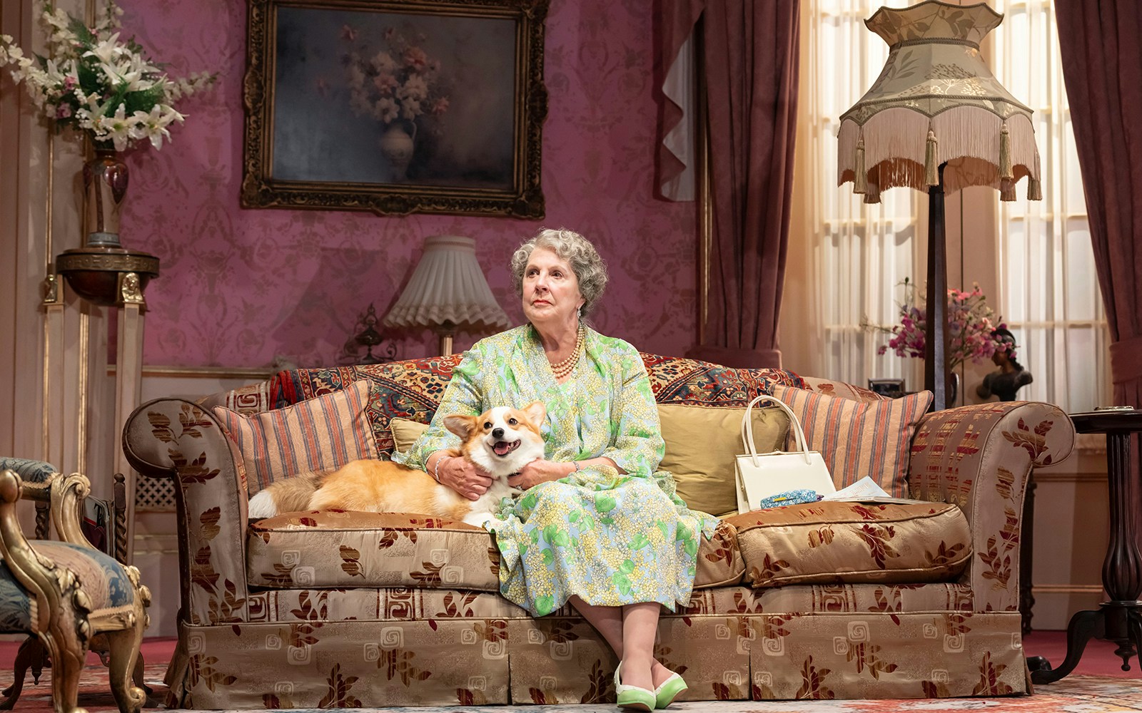 Elderly woman with a corgi on a vintage sofa in a classic living room setting.