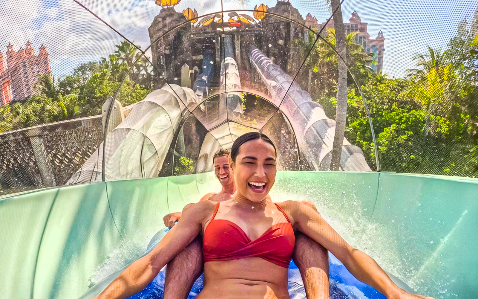Couple enjoying a water slide at Atlantis Aquaventure, Nassau, Bahamas.