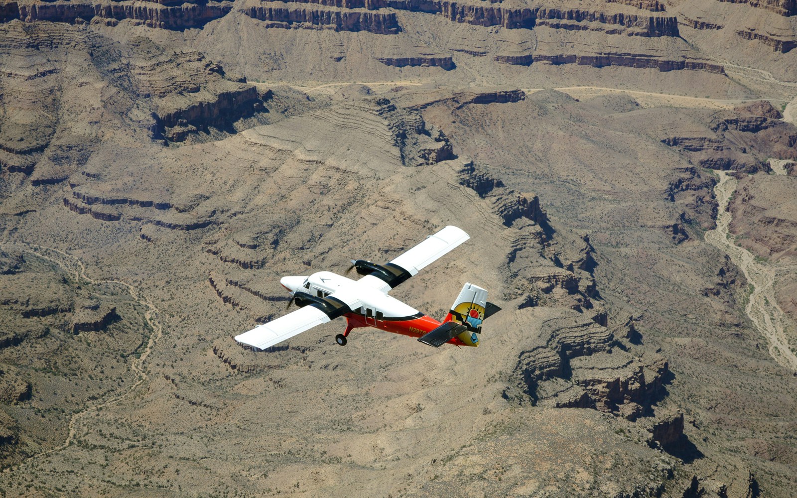 Plane flying over Grand Canyon South Rim, showcasing vast canyon landscape, Las Vegas airplane tour.