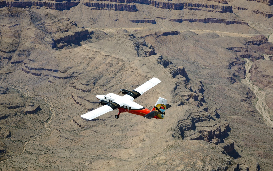 Plane flying over the Grand Canyon's rugged landscape.