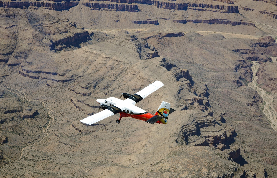 Plane flying over Grand Canyon South Rim, showcasing vast canyon landscape, Las Vegas airplane tour.