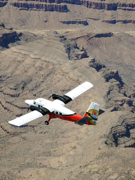 Plane flying over the Grand Canyon's rugged landscape.