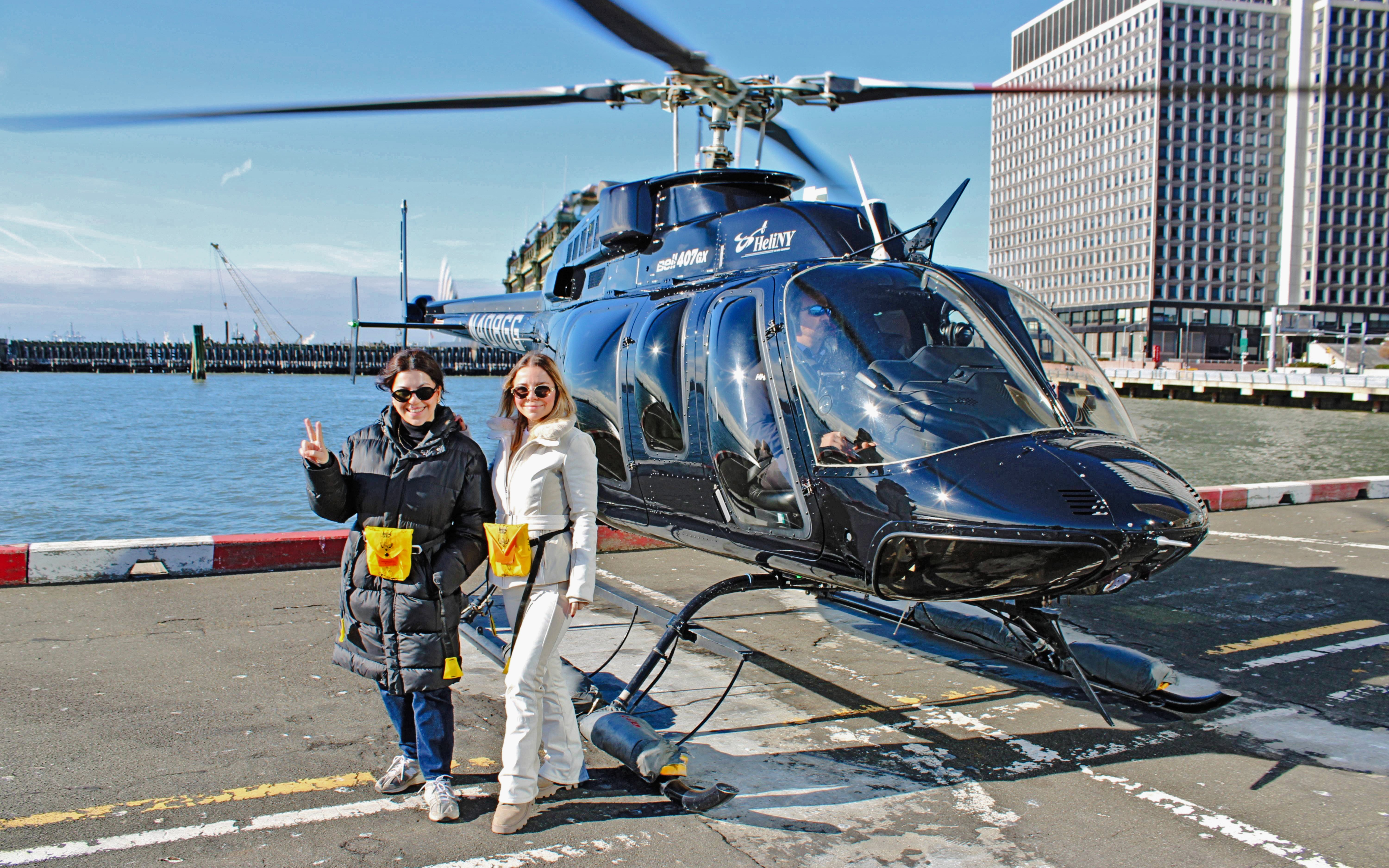 Helicopter tour departure from New York City helipad with two people ready to board.