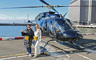 Helicopter tour departure from New York City helipad with two people ready to board.