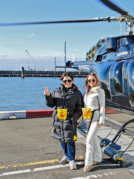 Helicopter tour departure from New York City helipad with two people ready to board.