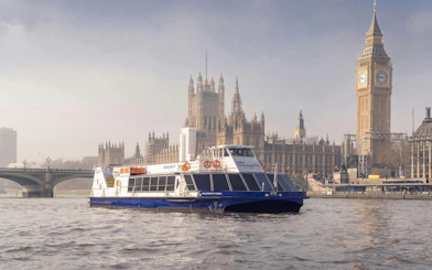 River cruise boat on the Thames with Big Ben and Westminster in London.