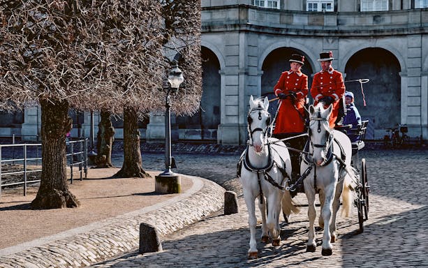 Horse-drawn carriage with guards in red uniforms at Amalienborg Palace, Copenhagen.