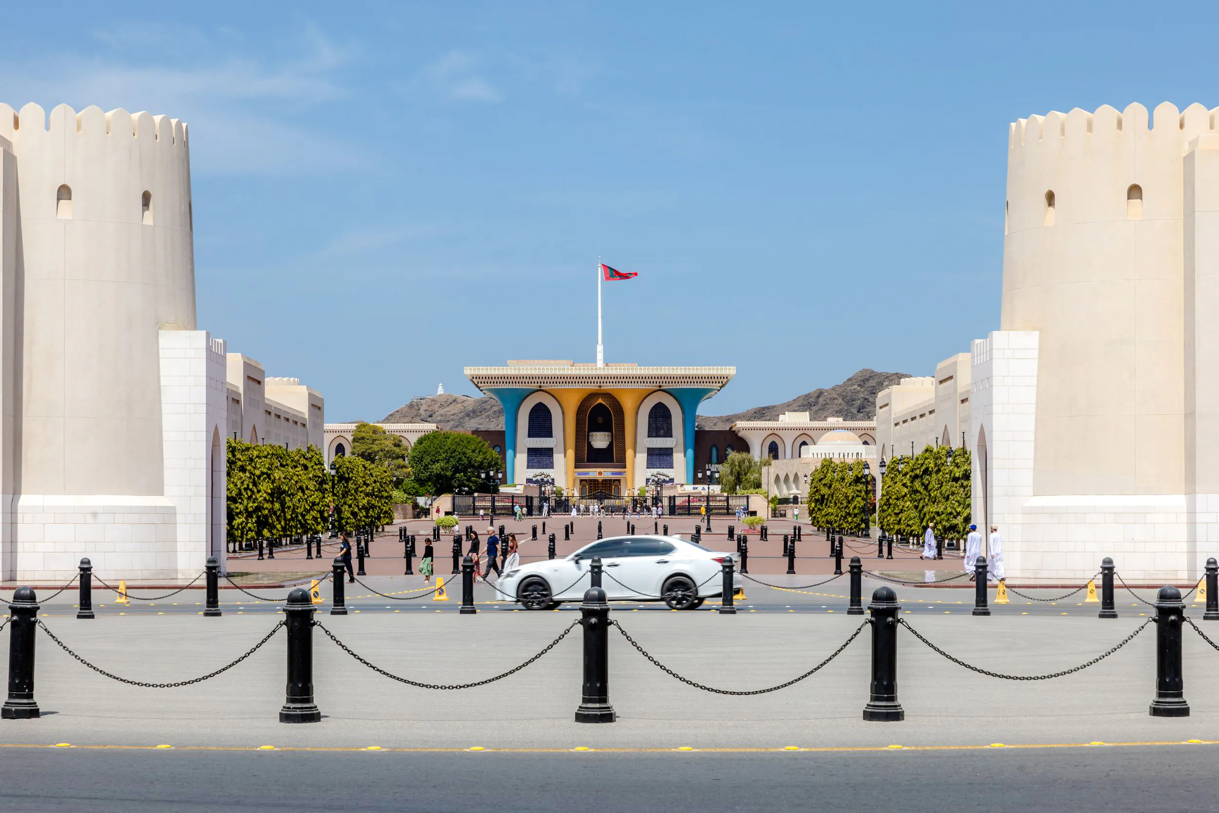 Sultan's Palace entrance with Omani flag, Muscat City Highlights Tour.
