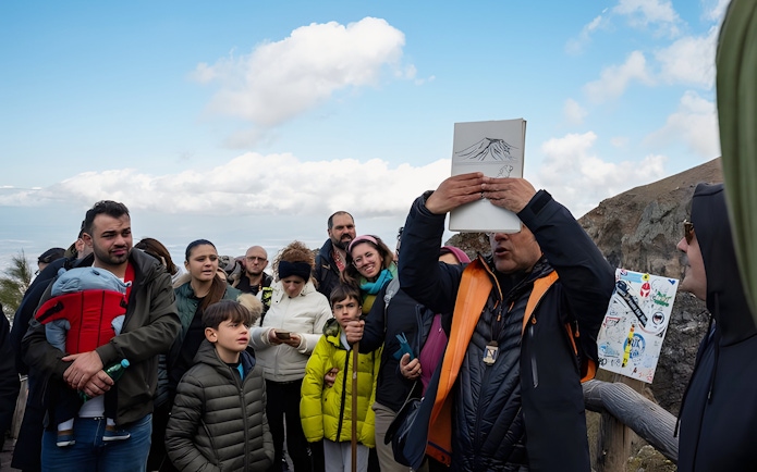 Tour group listening to a guide at Vesuvius National Park near Naples, Italy.