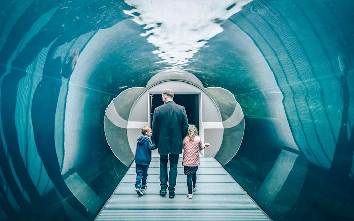 Family walking through aquarium tunnel in Copenhagen.
