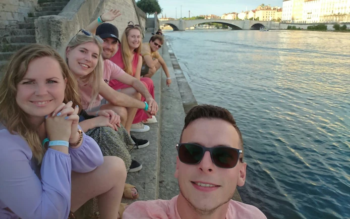 Group enjoying Lyon Old Town by the river during a self-guided city exploration game.