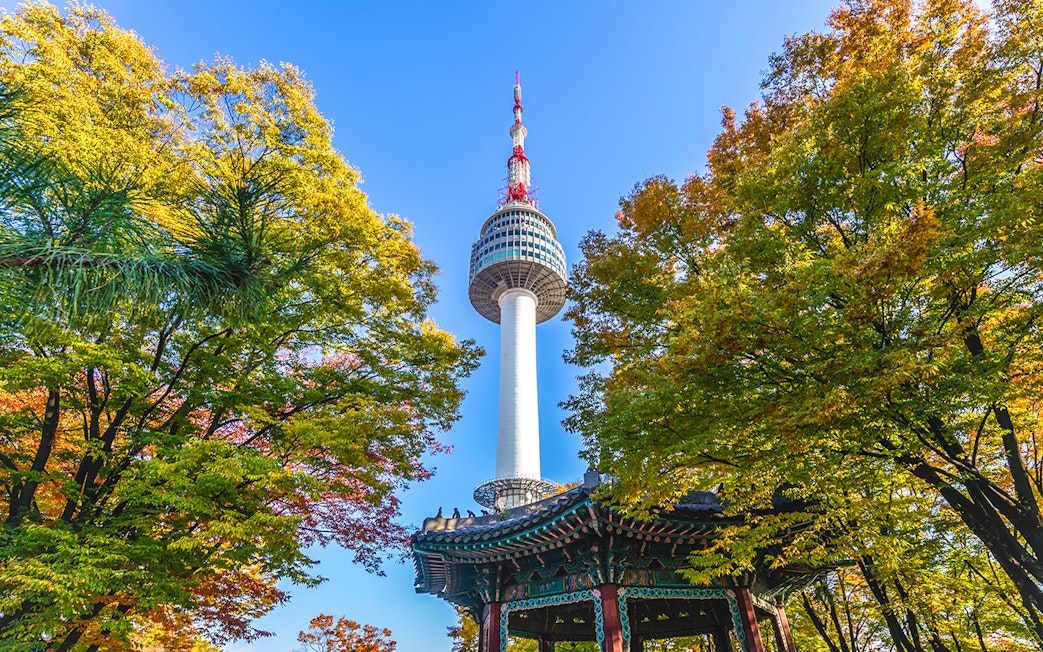 Seoul Tower surrounded by colorful autumn leaves in Seoul, South Korea.