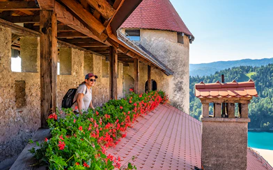 Guest exploring Bled Castle terrace with scenic view of Lake Bled.