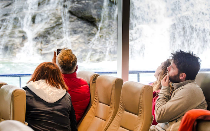 Passengers viewing waterfalls from a Geiranger Silent Fjord Cruise.