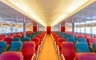 Ferry interior with rows of red and blue seats on the Singapore to Bintan Resorts route.