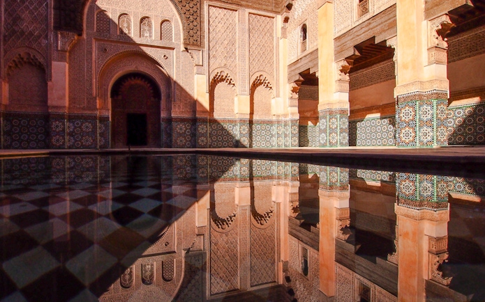 Ben Youssef Madrasa courtyard with intricate tilework in Marrakech, Morocco.