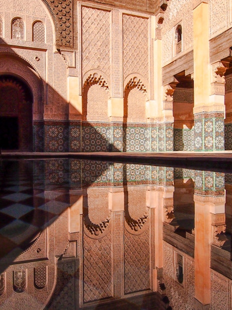 Ben Youssef Madrasa courtyard with intricate tilework in Marrakech, Morocco.