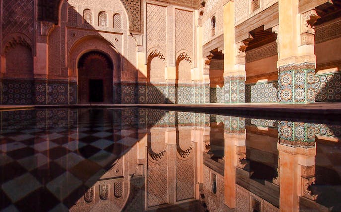 Ben Youssef Madrasa courtyard with intricate tilework in Marrakech, Morocco.