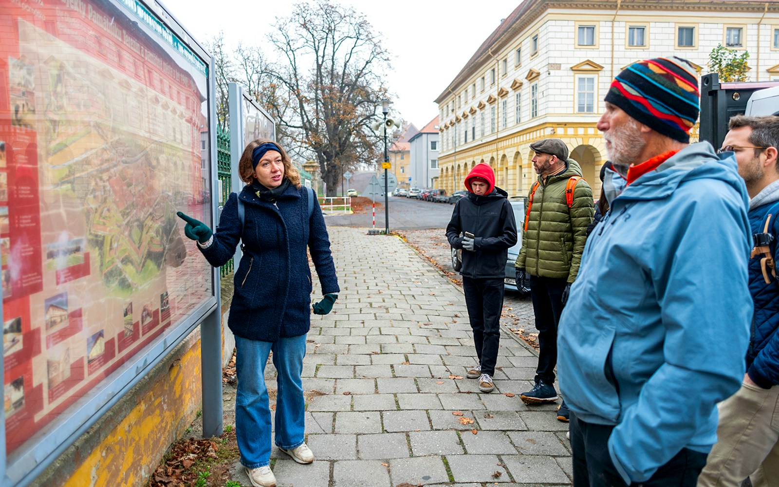 Guide explaining map to tourists during Terezin Concentration Camp tour.