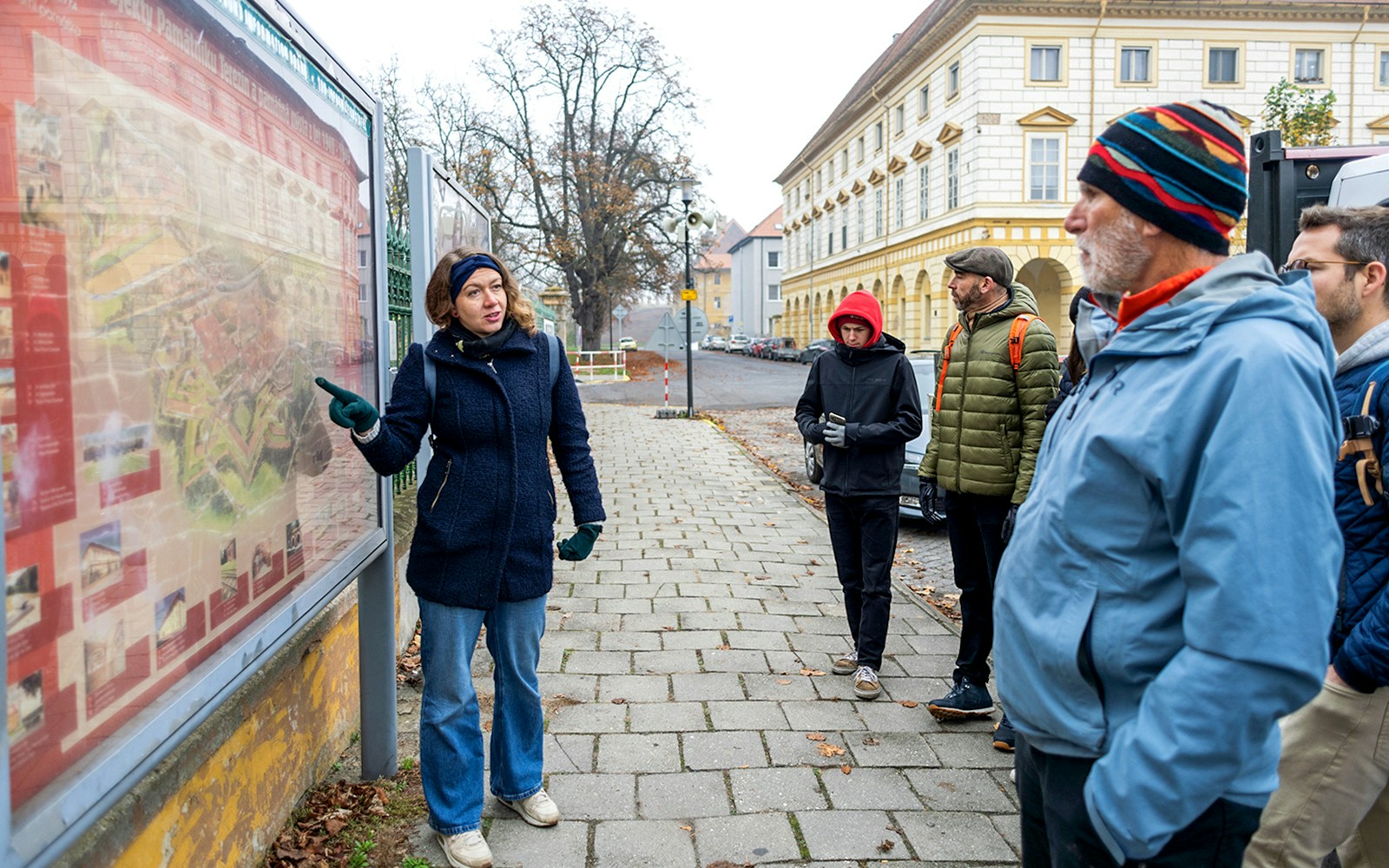 Guide explaining map to tourists during Terezin Concentration Camp tour.