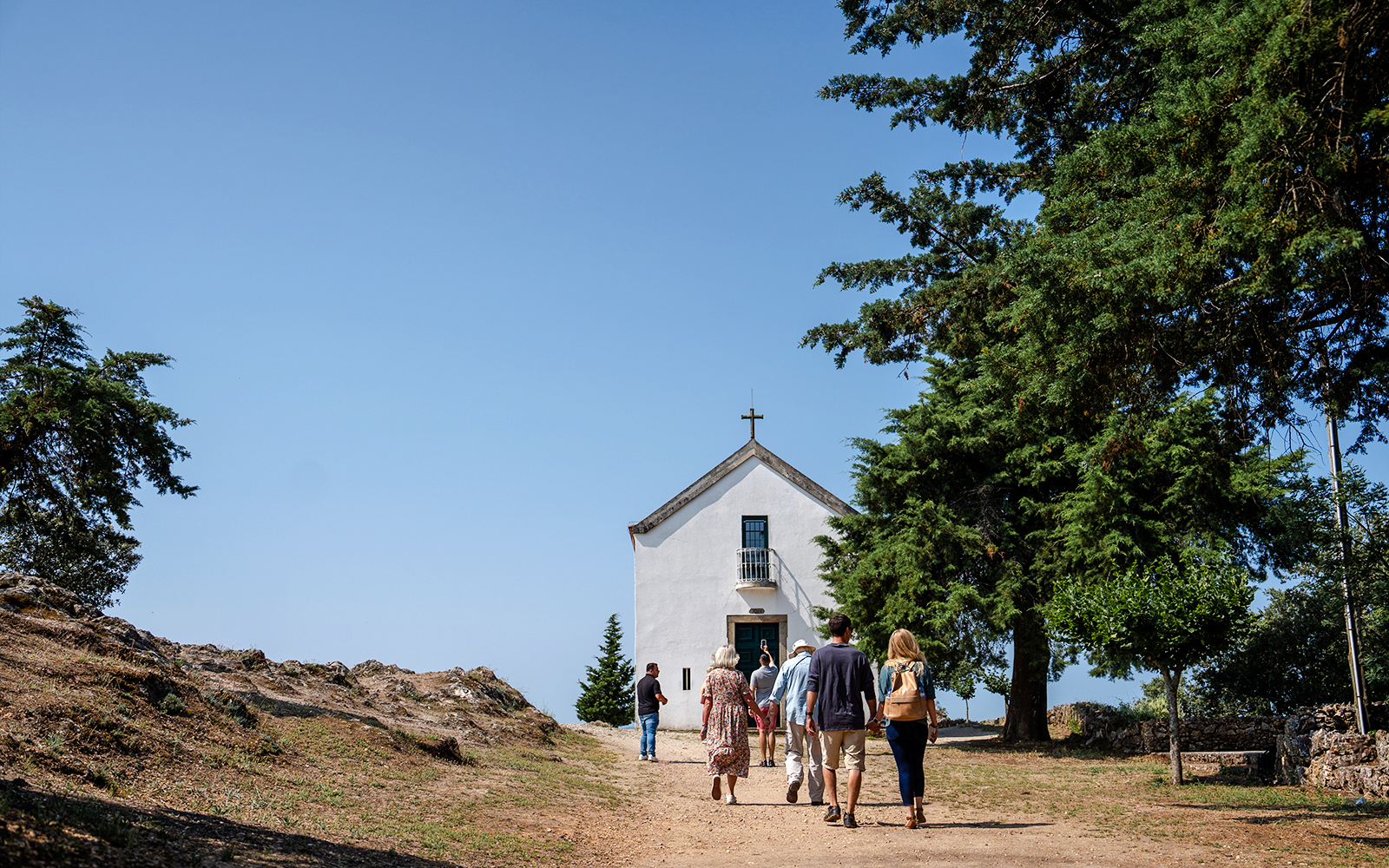 Visitors approaching Capela de São Leonardo at a scenic viewpoint in Douro Valley, Portugal.