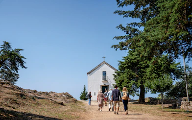 Visitors approaching Capela de São Leonardo at a scenic viewpoint in Douro Valley, Portugal.