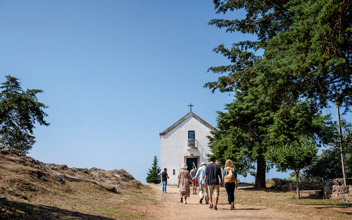 Visitors approaching Capela de São Leonardo at a scenic viewpoint in Douro Valley, Portugal.