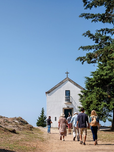 Visitors approaching Capela de São Leonardo at a scenic viewpoint in Douro Valley, Portugal.