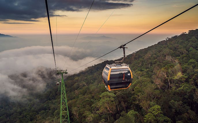 Cable car ascending over lush forest at Sun World Ba Na Hills, Vietnam.