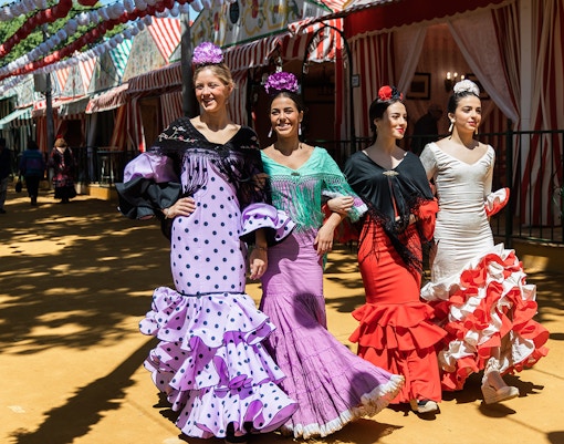 Flamenco dancers in colorful dresses at the Seville Fair.