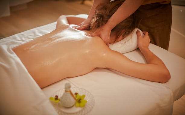 Back massage with organic aromatherapy oils in a spa setting.