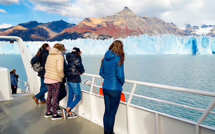 Tourists on cruise deck viewing Perito Moreno Glacier in Argentina.