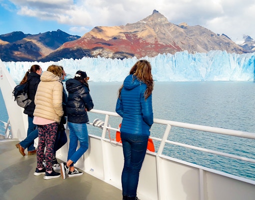 Tourists on cruise deck viewing Perito Moreno Glacier in Argentina.
