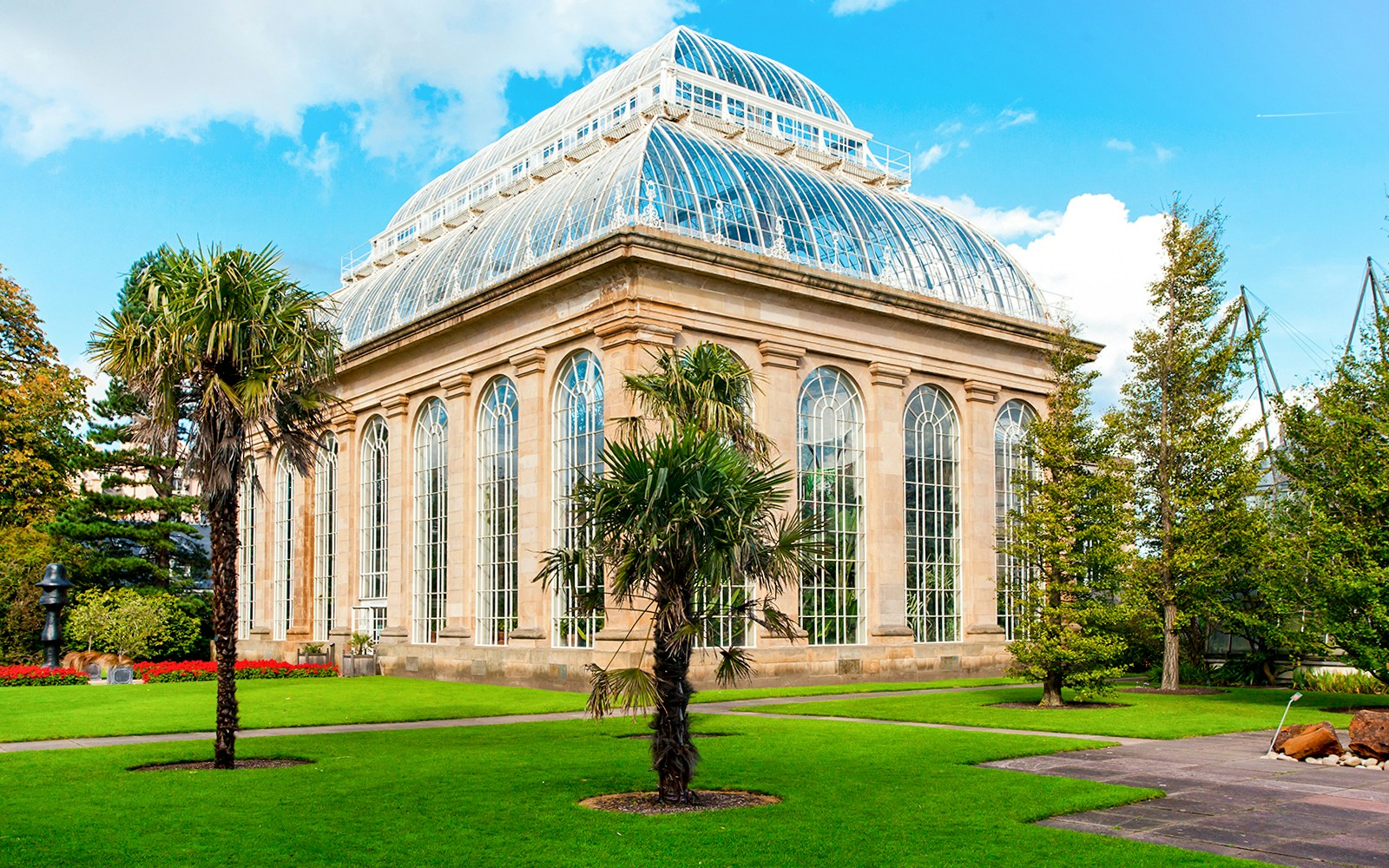 Greenhouse in Royal Botanic Gardens with palm trees and glass architecture.