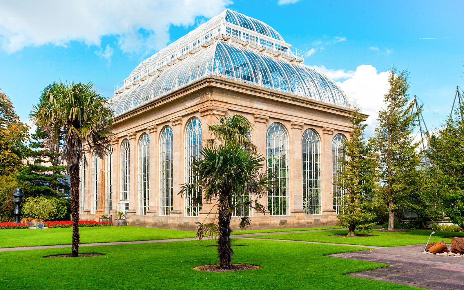 Greenhouse in Royal Botanic Gardens with palm trees and glass architecture.