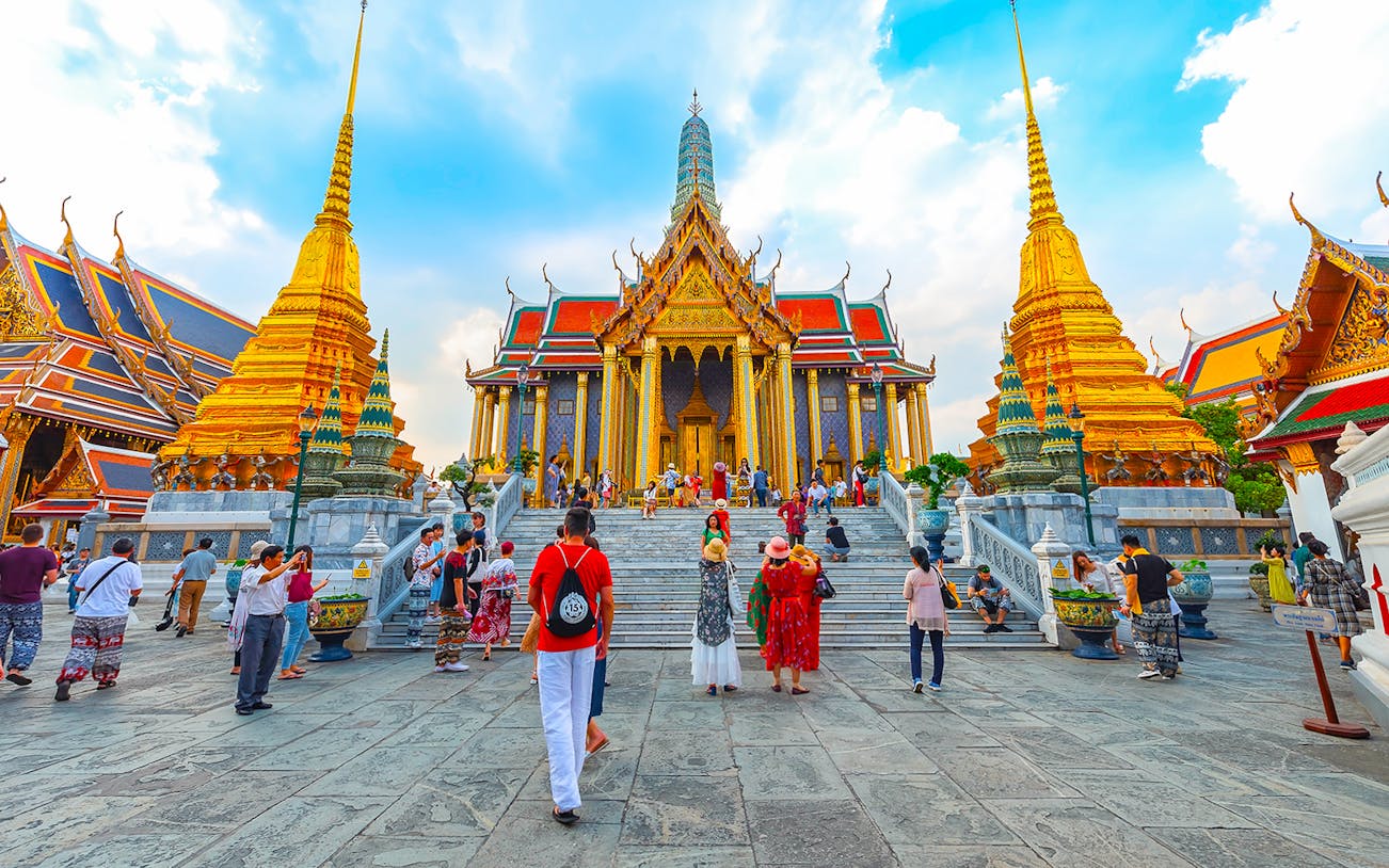 Grand Palace in Bangkok with tourists exploring the temple grounds.