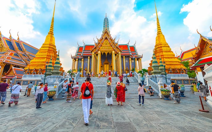 Grand Palace in Bangkok with tourists exploring the temple grounds.