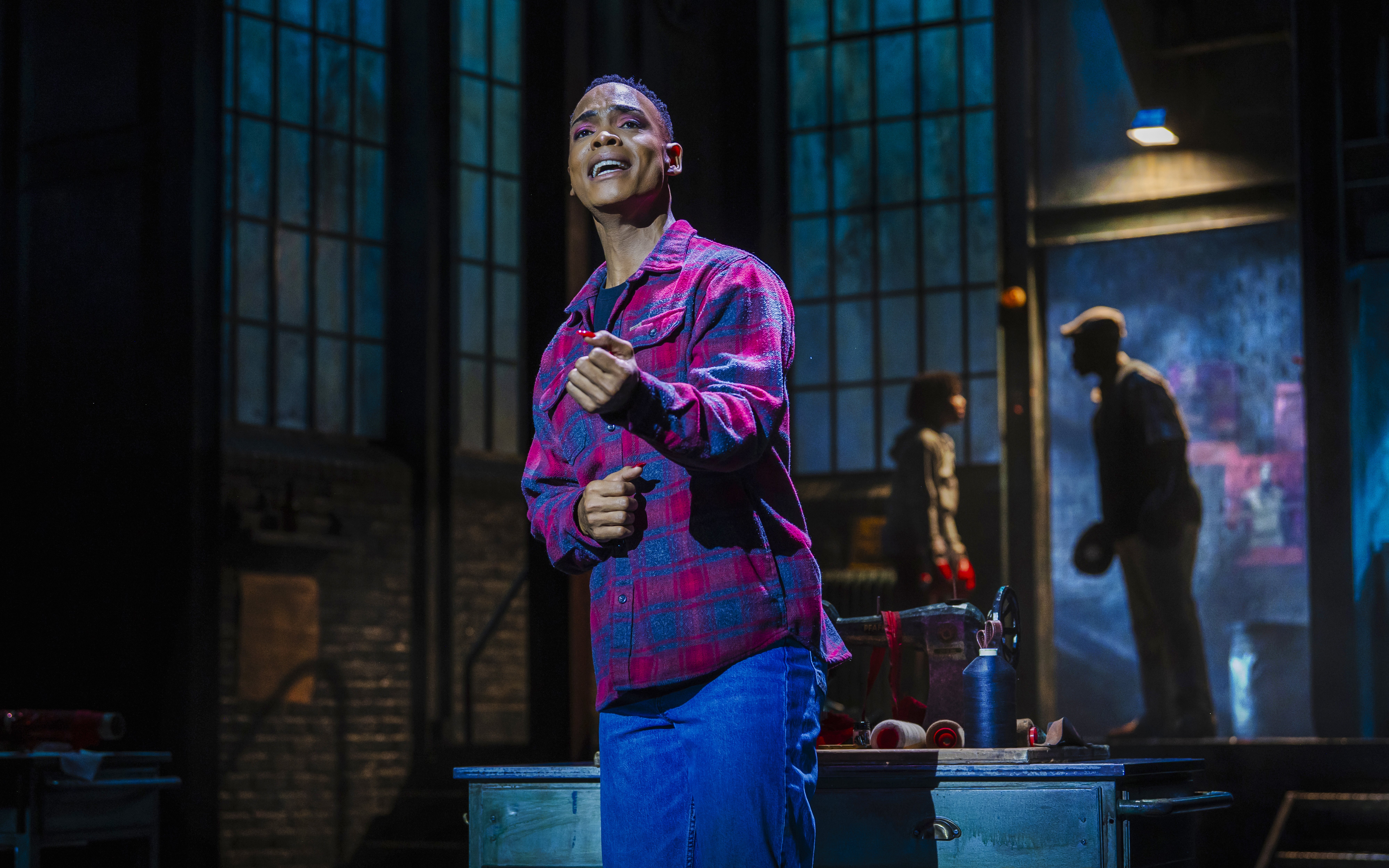 Performer singing on stage during Kinky Boots production.