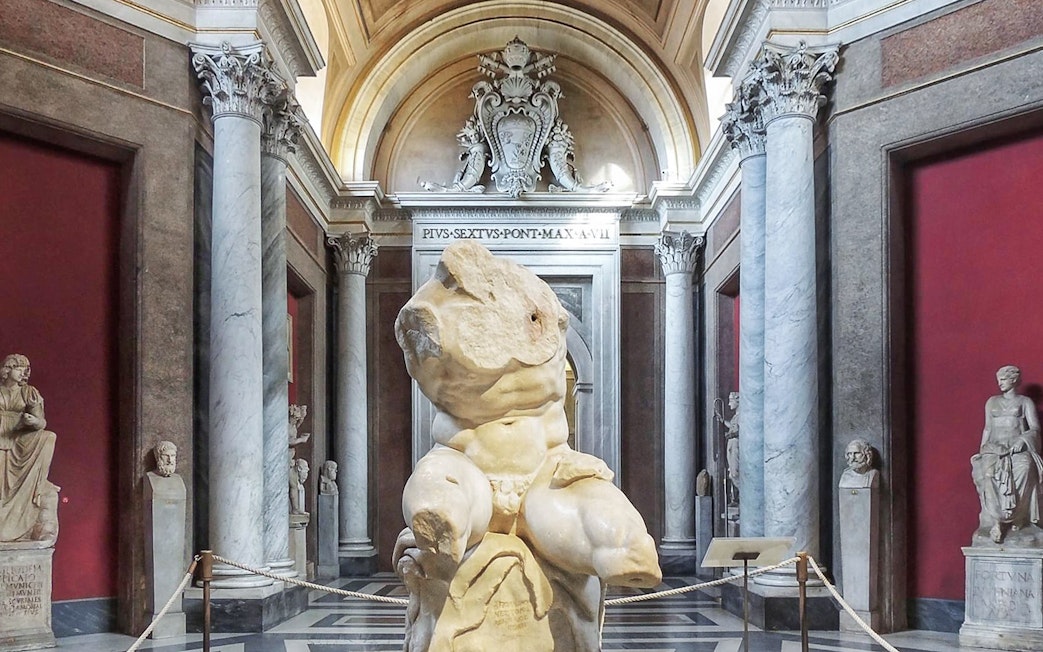 Belvedere Torso sculpture in the Vatican Museum's ornate gallery.