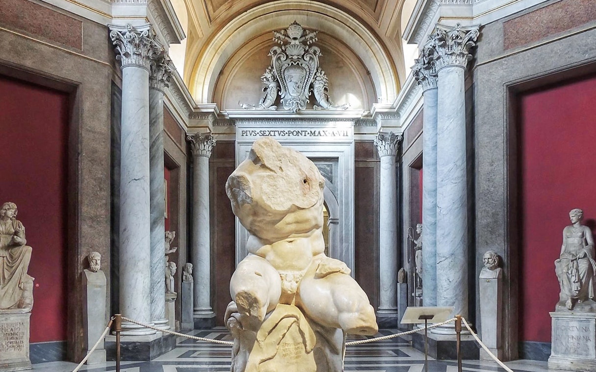 Belvedere Torso sculpture in the Vatican Museum's ornate gallery.