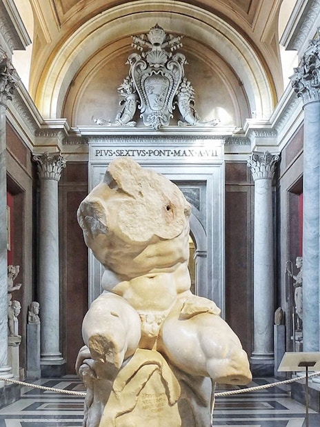 Belvedere Torso sculpture in the Vatican Museum's ornate gallery.