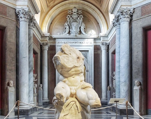 Belvedere Torso sculpture in the Vatican Museum's ornate gallery.
