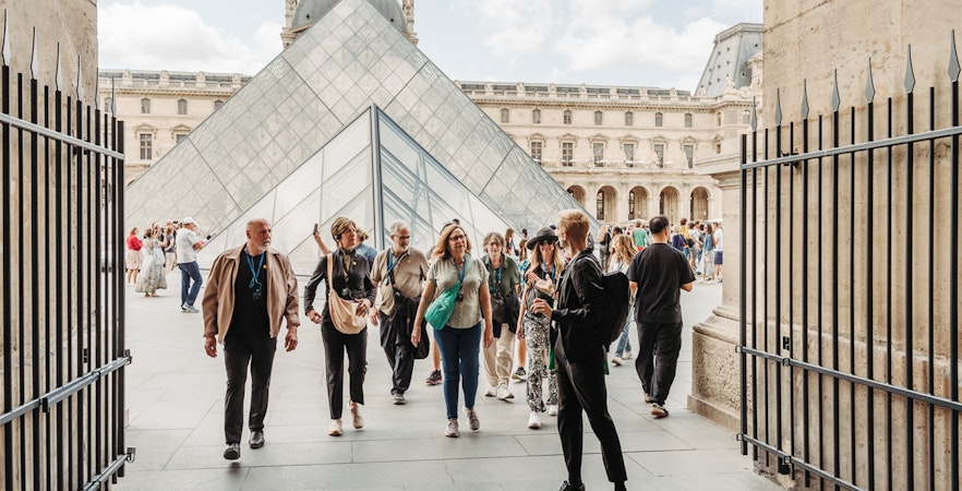 Tour group at the Louvre Pyramid entrance in Paris, France.