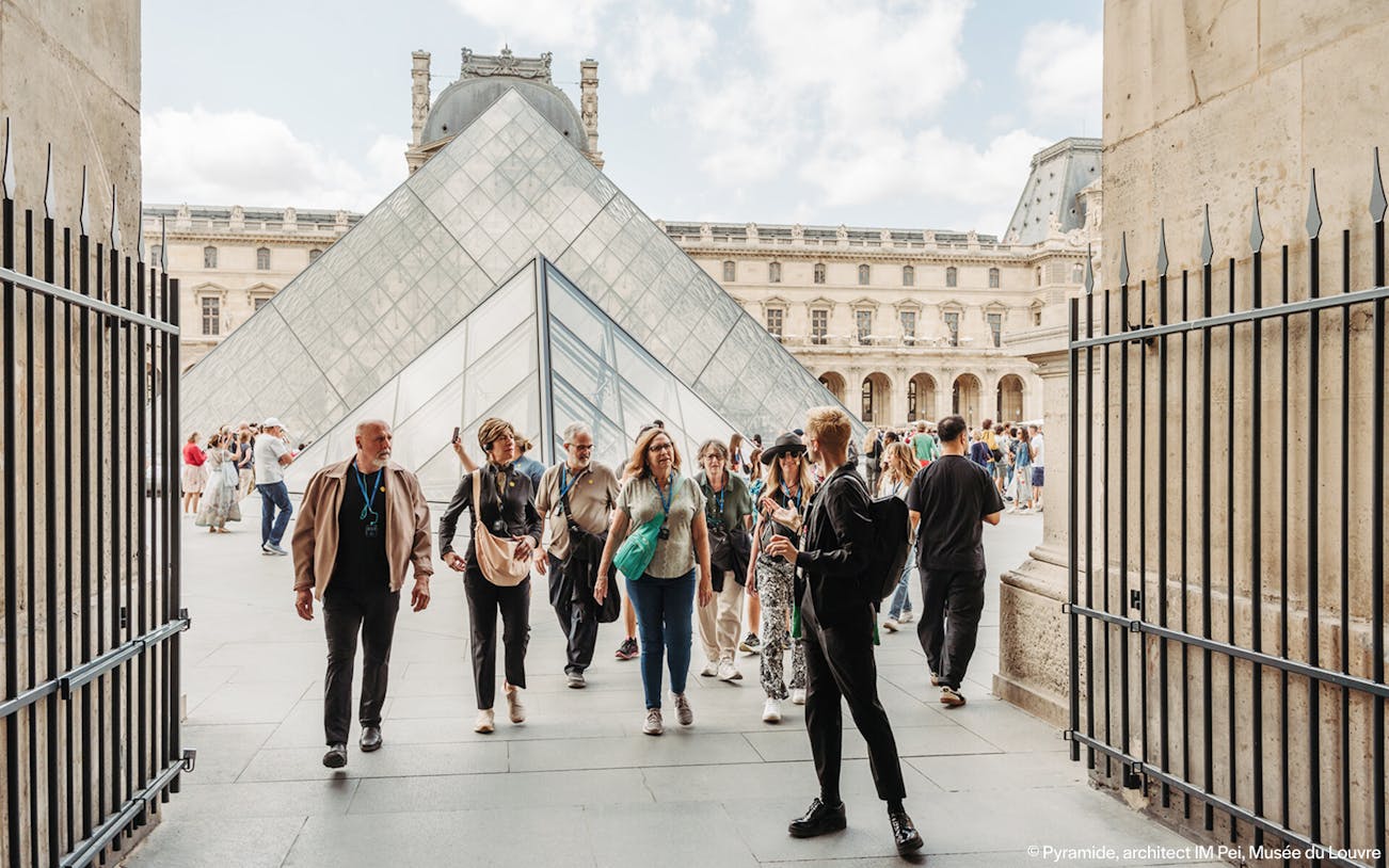 Tour group at the Louvre Pyramid entrance in Paris, France.