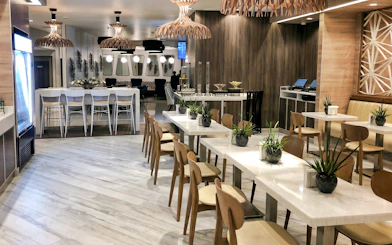Dining area at MERA Business Lounge, Cancun International Airport, featuring modern seating and decor.