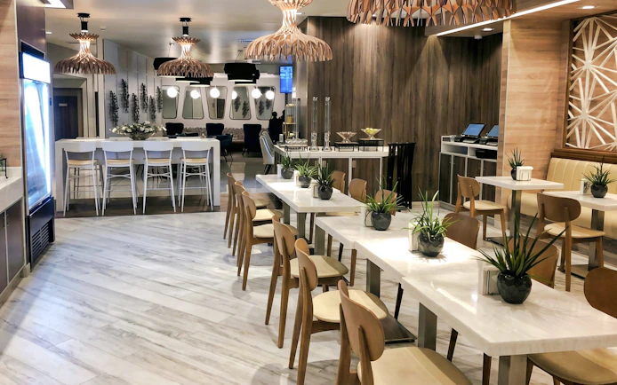 Dining area at MERA Business Lounge, Cancun International Airport, featuring modern seating and decor.